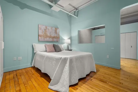 a bedroom with a bed and wooden floor
