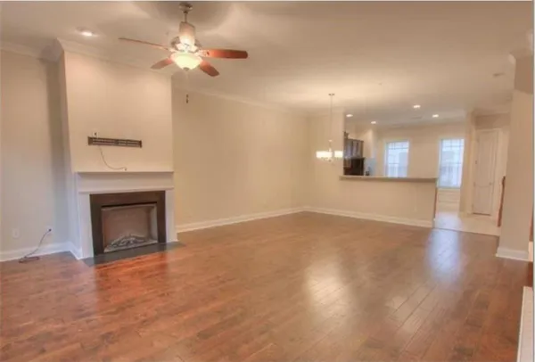 an empty room with wooden floor and a fireplace