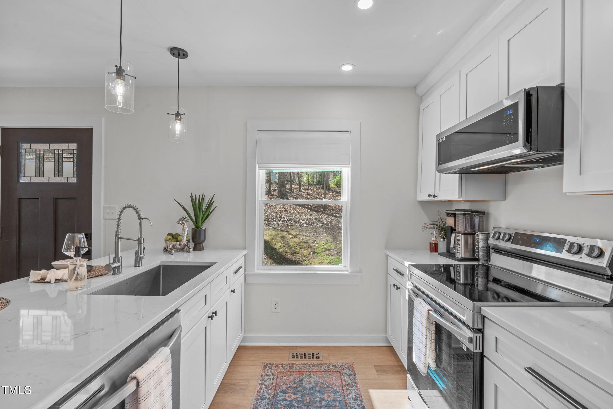 211 Fleming Drive Durham, NC 27712 - Photo 10 of 34 a kitchen with kitchen island granite countertop a sink stainless steel appliances and cabinets
