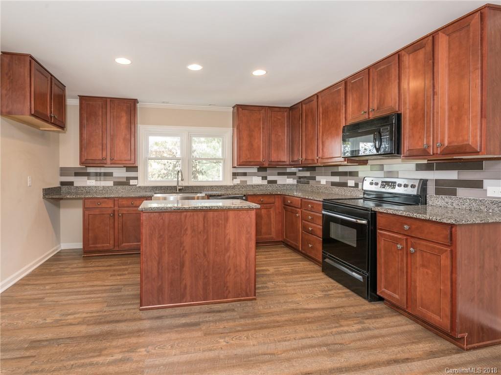 2022 Long Hope Road Monroe, NC 28112 - Photo 14 of 28 a kitchen with stainless steel appliances granite countertop a stove top oven a sink dishwasher and a microwave oven on the wooden floor
