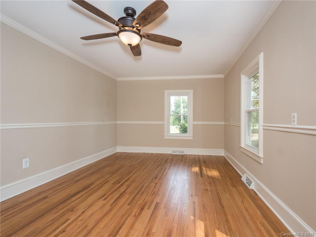 2022 Long Hope Road Monroe, NC 28112 - Photo 17 of 28 an empty room with wooden floor fan and windows