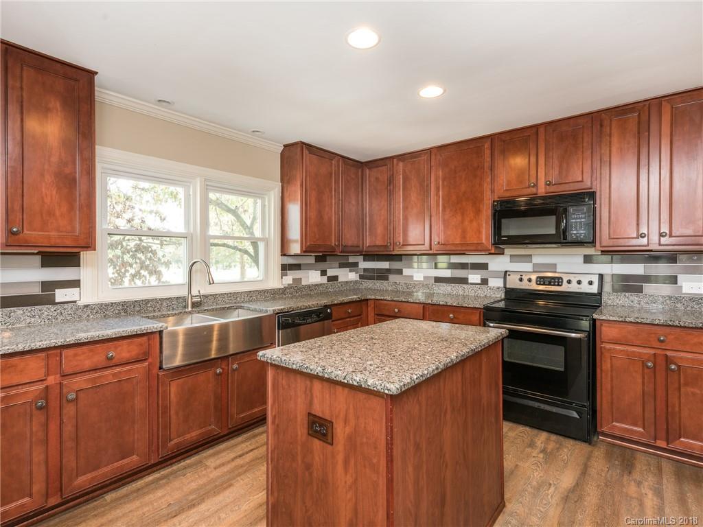 2022 Long Hope Road Monroe, NC 28112 - Photo 3 of 28 a kitchen with stainless steel appliances granite countertop wooden cabinets a stove a sink and dishwasher with wooden floor
