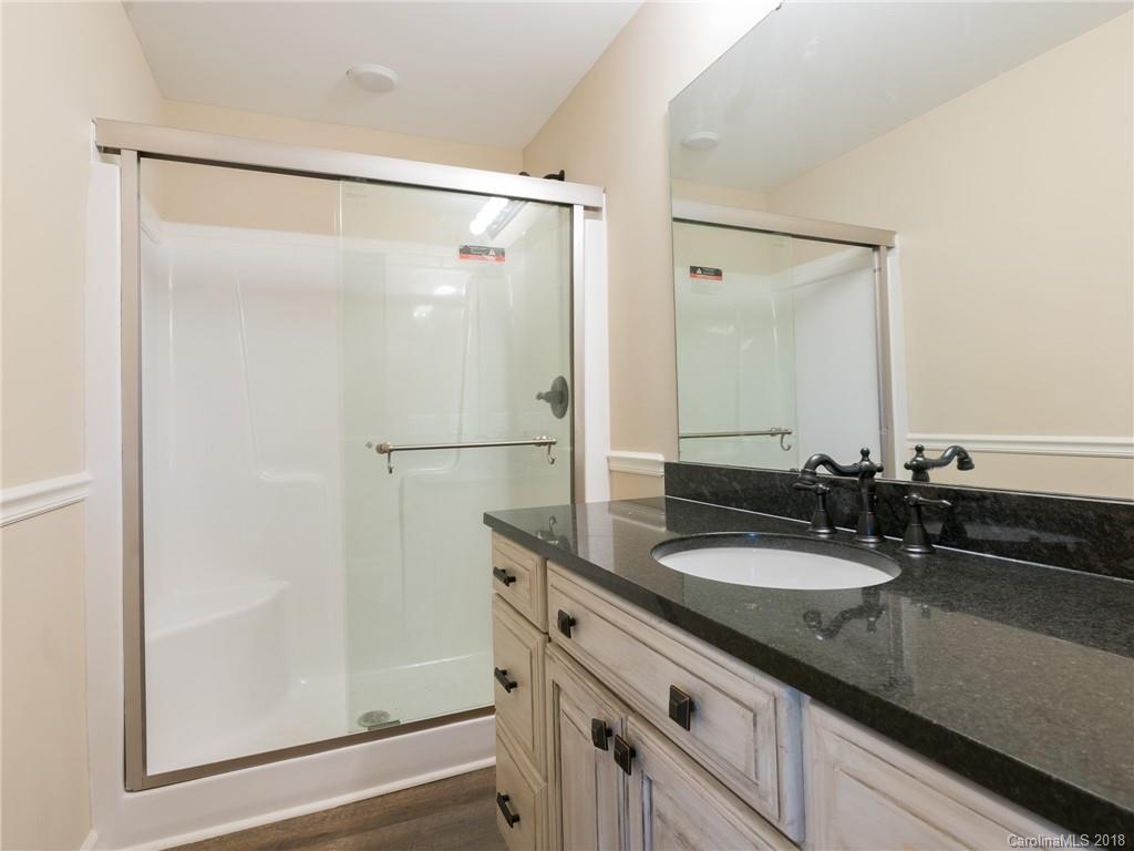 2022 Long Hope Road Monroe, NC 28112 - Photo 5 of 28 a bathroom with a granite countertop shower sink and mirror