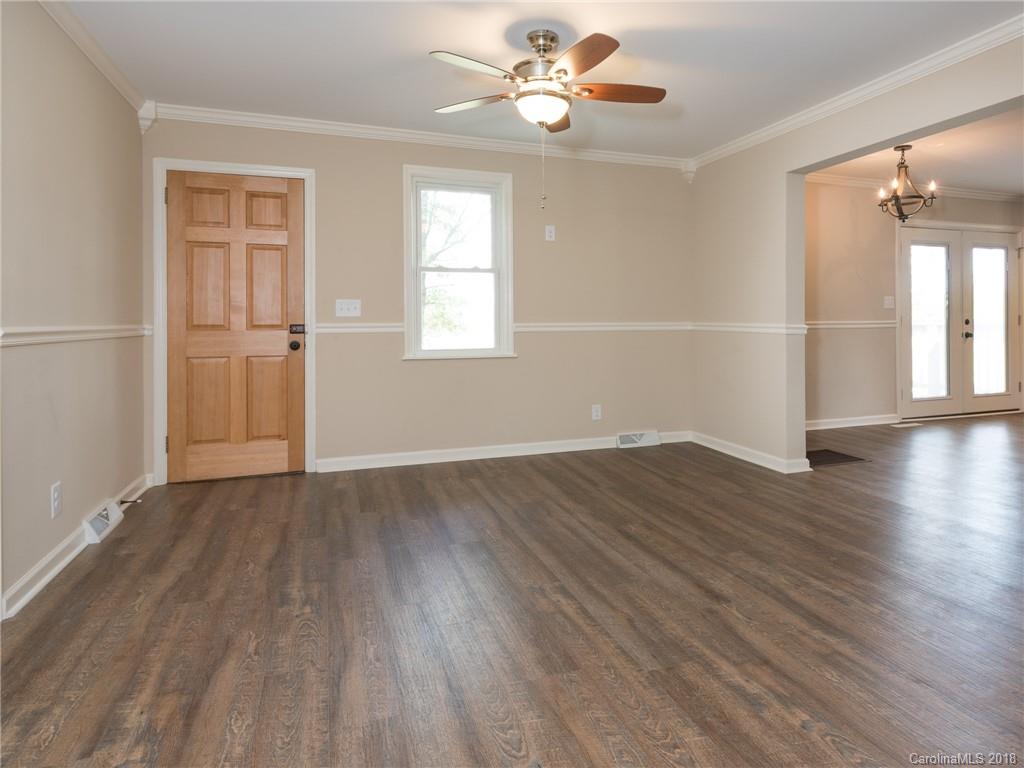 2022 Long Hope Road Monroe, NC 28112 - Photo 8 of 28 an empty room with wooden floor chandelier fan and windows