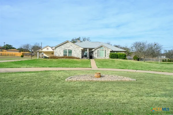 a front view of a house with a garden and trees