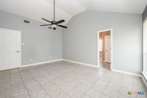 an empty room with a ceiling fan and carpet