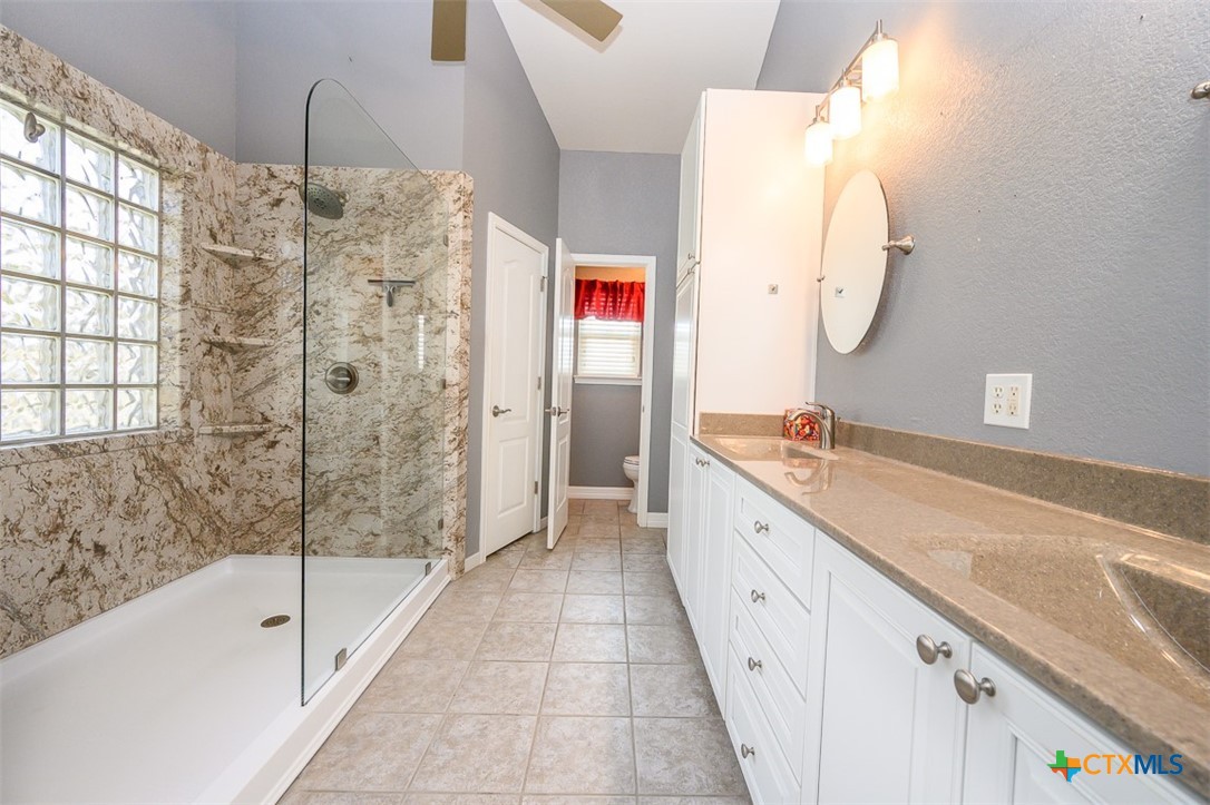 138 County Road 4963 Kempner, TX 76539 - Photo 23 of 46 a spacious bathroom with a granite countertop sink a mirror and a bathtub