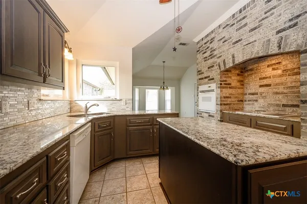 a kitchen with a sink stove and cabinets
