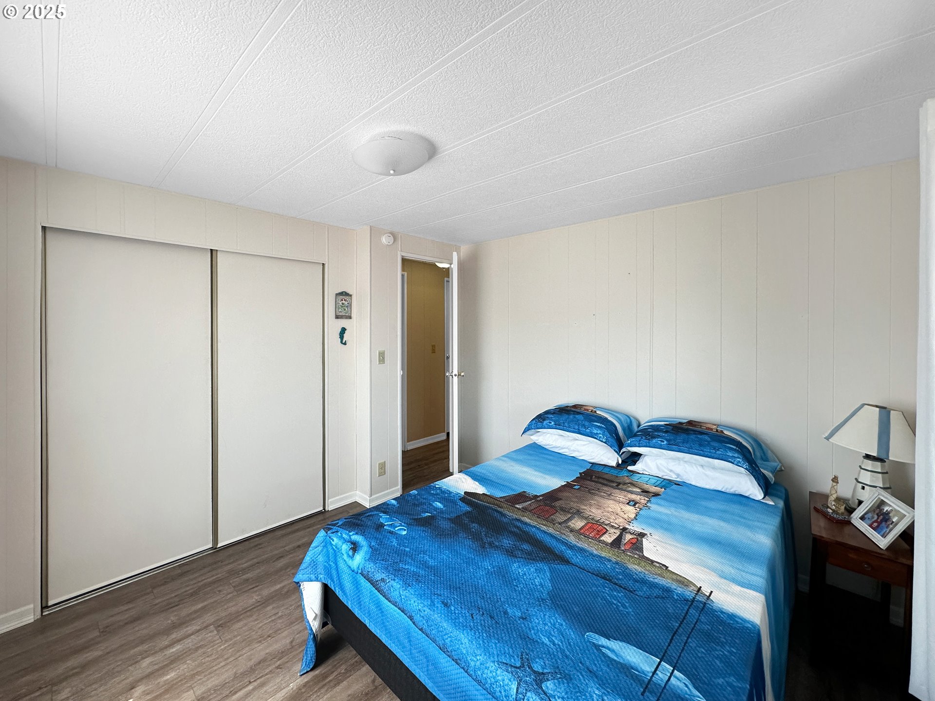 15889 Sunset Strip, Unit 35 Brookings, OR 97415 - Photo 15 of 21 a bedroom with a bed and wooden floor