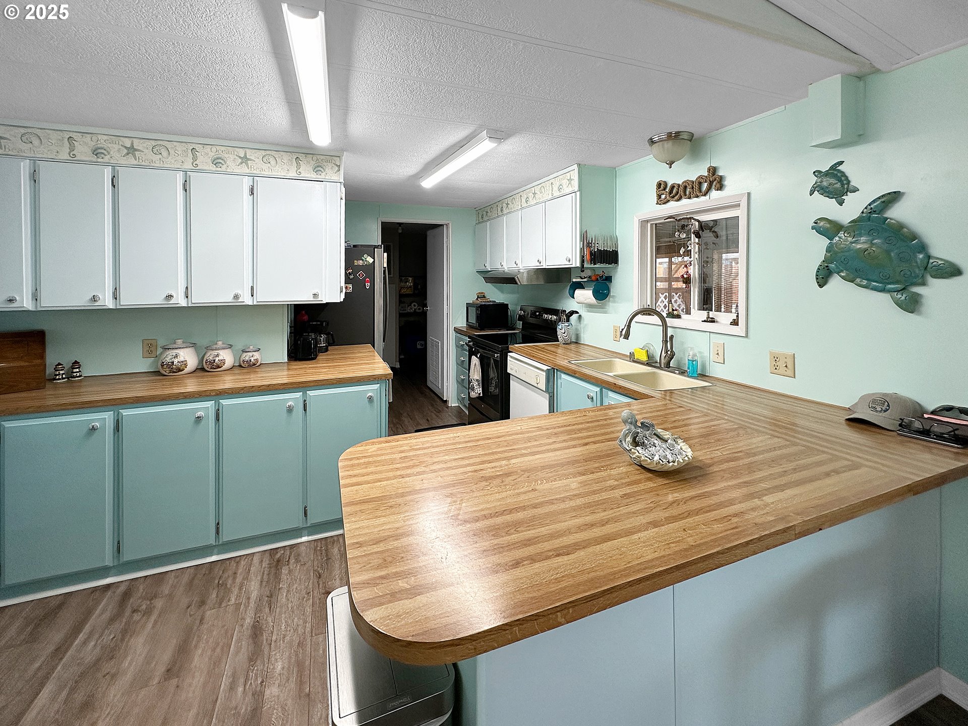 15889 Sunset Strip, Unit 35 Brookings, OR 97415 - Photo 7 of 21 a kitchen with stainless steel appliances kitchen island granite countertop a sink dishwasher and cabinets with wooden floor