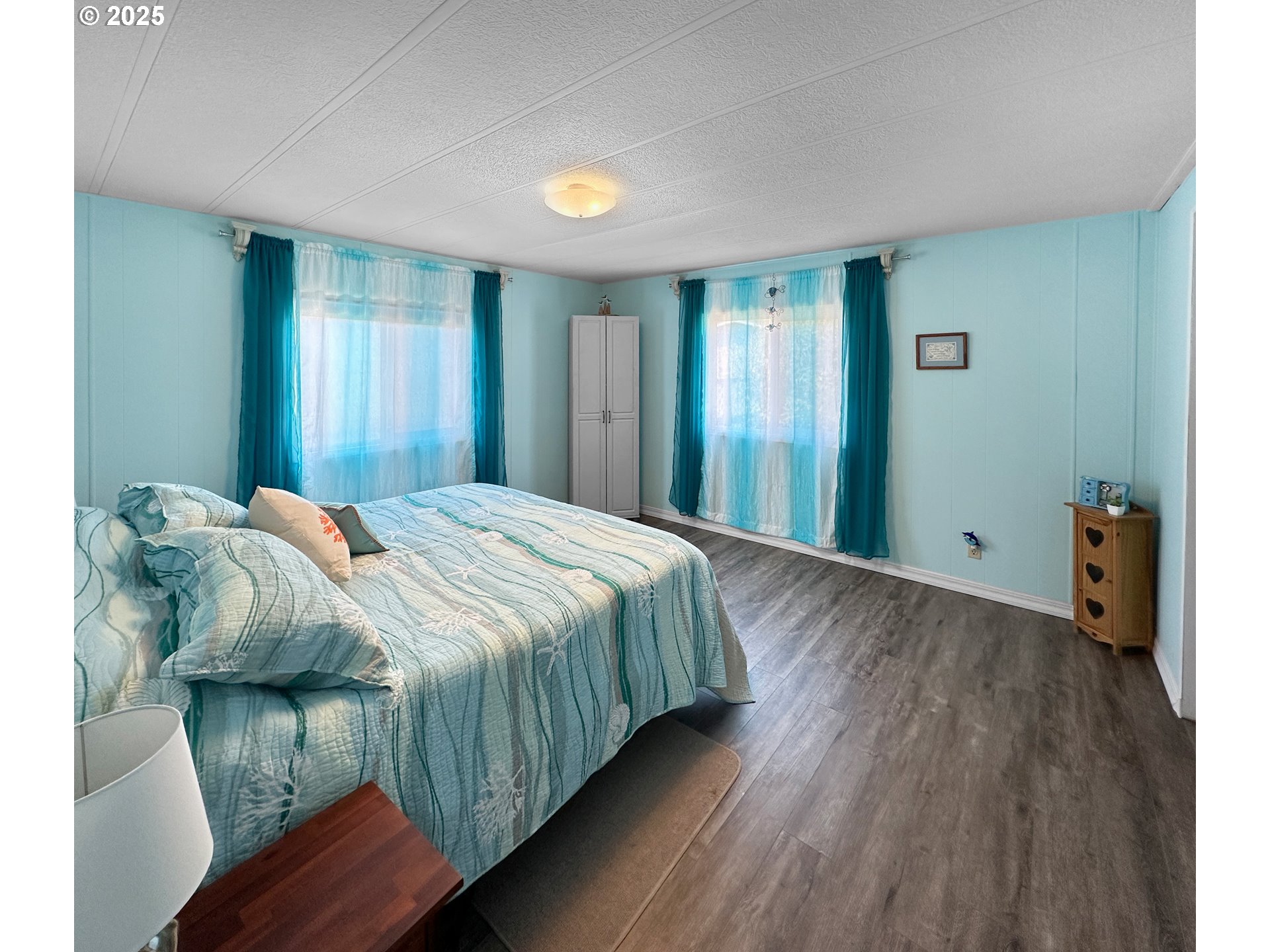 15889 Sunset Strip, Unit 35 Brookings, OR 97415 - Photo 9 of 21 a bedroom with a bed and wooden floor