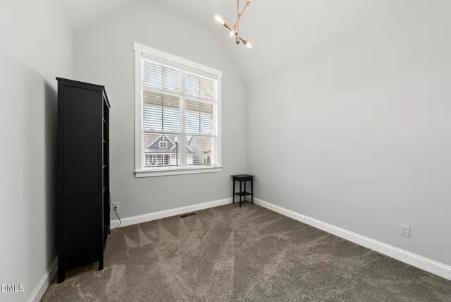 an empty room with windows and cabinet