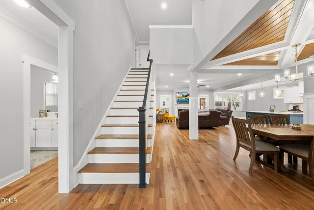 a view of a dining room with wooden floor and stairs