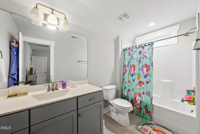 a bathroom with a sink a toilet and shower curtain