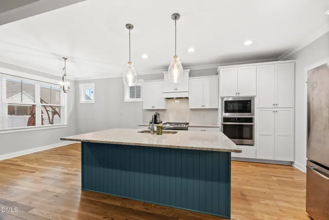a kitchen with kitchen island a stove a sink and a wooden floors