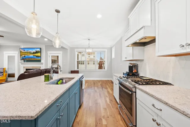 a kitchen with stainless steel appliances granite countertop a sink stove and cabinets