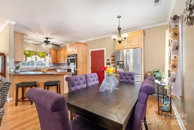 a dining room with furniture a chandelier and wooden floor