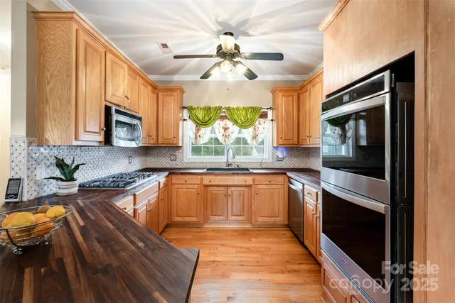 a kitchen with stainless steel appliances granite countertop a stove a sink and a microwave