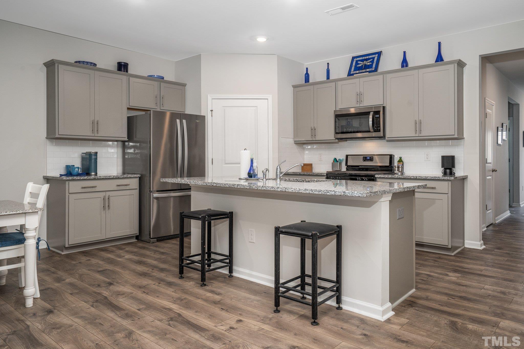 369 Lothian Rocky Mount, NC 27804 - Photo 7 of 32 a kitchen with stainless steel appliances a sink a stove a refrigerator cabinets and a dining table