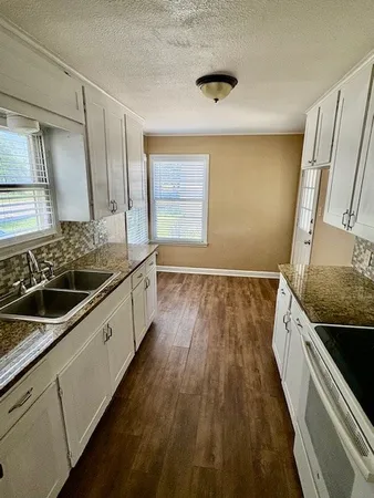 a bathroom with a granite countertop sink a large mirror and a shower