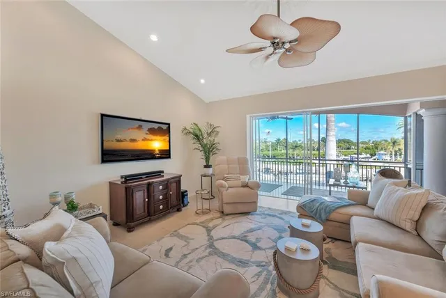 a living room with furniture a floor to ceiling window and a flat screen tv