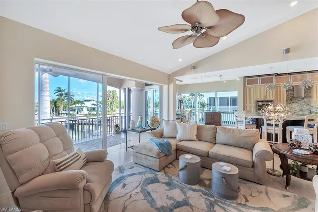 a living room with furniture ceiling fan and a large window