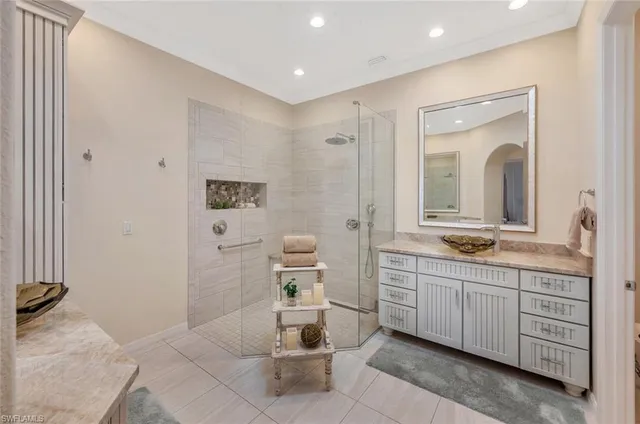 a spacious bathroom with a shower a sink and a mirror