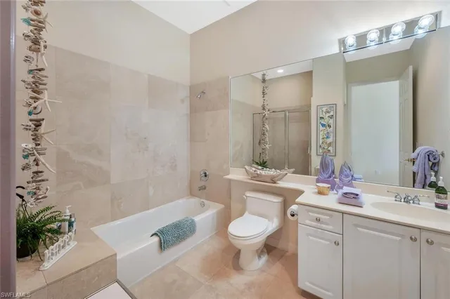 a bathroom with a granite countertop sink a toilet a mirror and shower