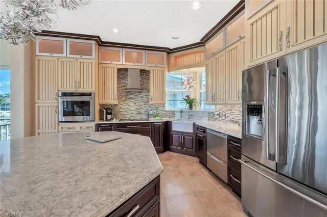 a kitchen with stainless steel appliances granite countertop a refrigerator a stove and a wooden floors