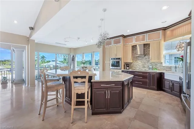 a kitchen with stainless steel appliances granite countertop table chairs stove and sink