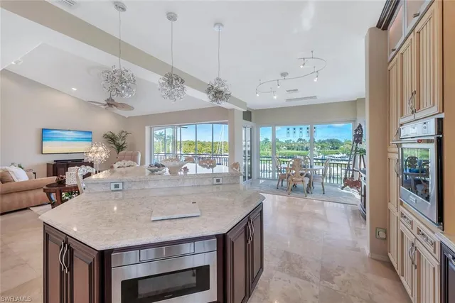 a room with kitchen island a large window a sink and living room view