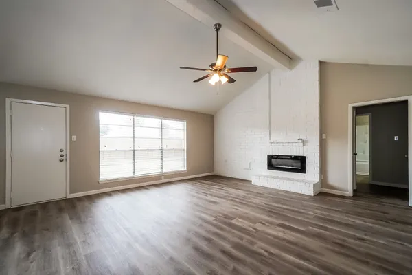 a view of an empty room with a fireplace and a window