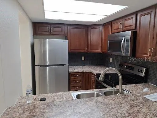 a kitchen with a refrigerator and a stove top oven