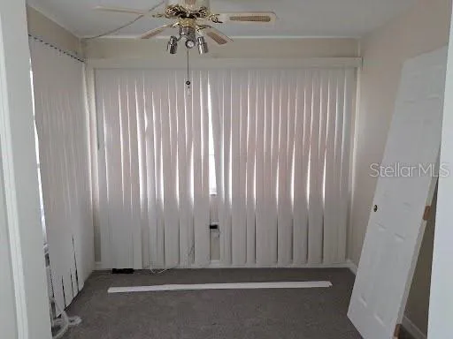 a view of a livingroom with a ceiling fan and window