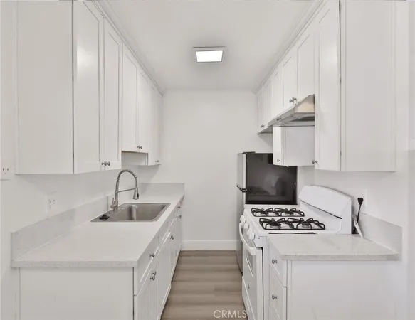 a white refrigerator freezer and a stove sitting inside of a kitchen