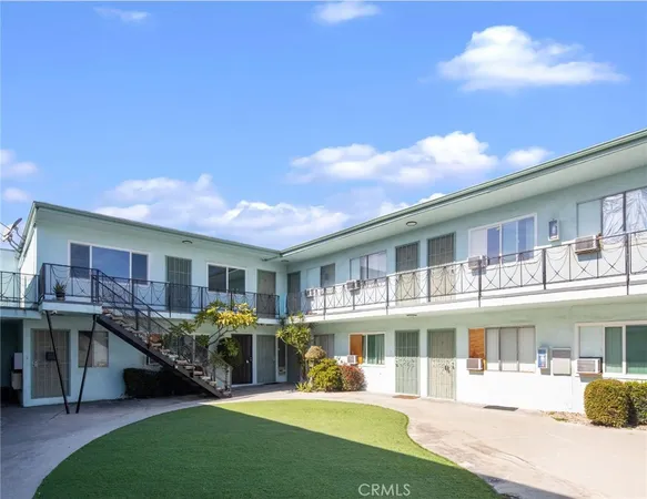 a front view of a residential apartment building with a yard