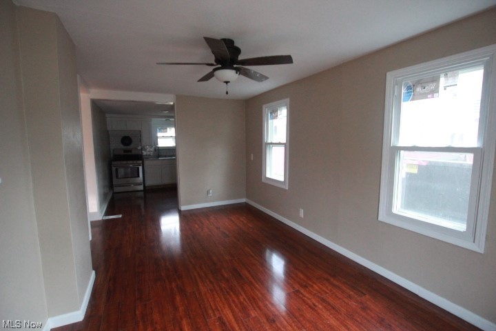 3606 Shelby Road Youngstown, OH 44511 - Photo 9 of 33 Empty room with dark hardwood / wood-style floors, ceiling fan, and a wealth of natural light
