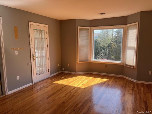 38 Hallock Avenue Smithtown, NY 11787 - Photo 11 of 16 a view of an empty room with wooden floor and a window