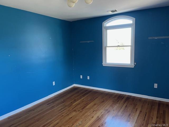 38 Hallock Avenue Smithtown, NY 11787 - Photo 12 of 16 an empty room with wooden floor and windows