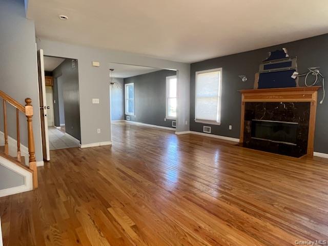 38 Hallock Avenue Smithtown, NY 11787 - Photo 4 of 16 an empty room with wooden floor fireplace and windows