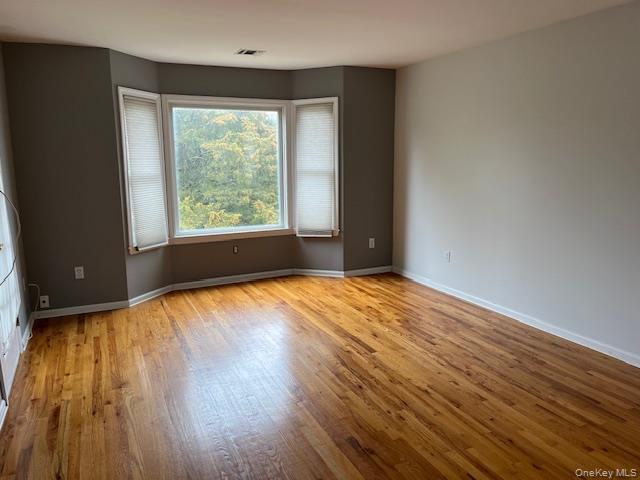 38 Hallock Avenue Smithtown, NY 11787 - Photo 10 of 16 a view of an empty room with wooden floor and a window