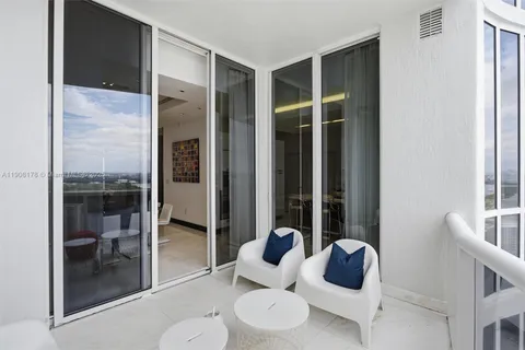 a view of roof deck with couches and potted plants