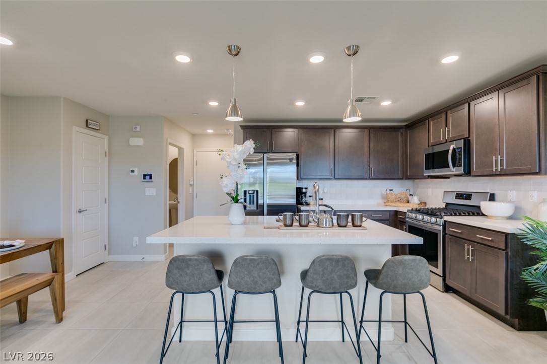 653 Pickled Pepper Place Henderson, NV 89011 - Photo 14 of 35 Culinary delights await in this modern kitchen with an inviting island and sleek appliances.