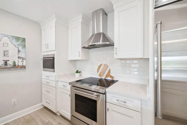 a kitchen with white cabinets and appliances