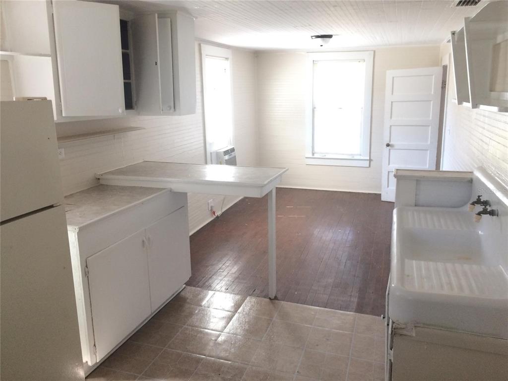 a view of a kitchen with a sink and dishwasher with wooden floor