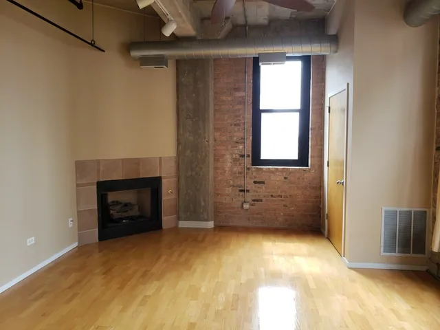 a view of an empty room with a fireplace and a window