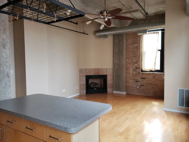 a view of an empty room with a fireplace and a window