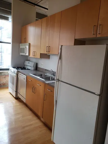 a kitchen with stainless steel appliances a refrigerator sink and white cabinets