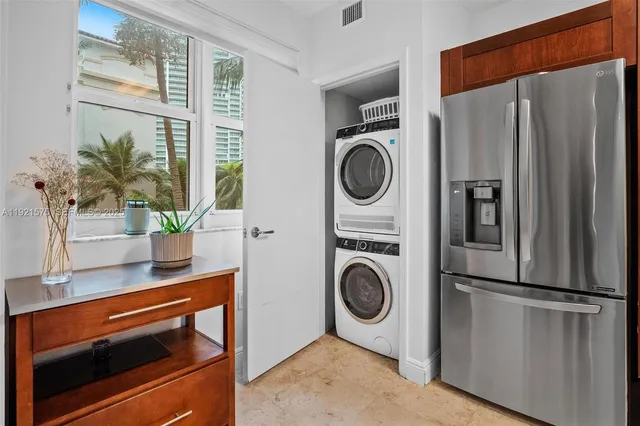 a kitchen with a refrigerator and a potted plant