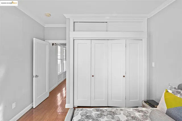 a view of a bedroom with wooden floor